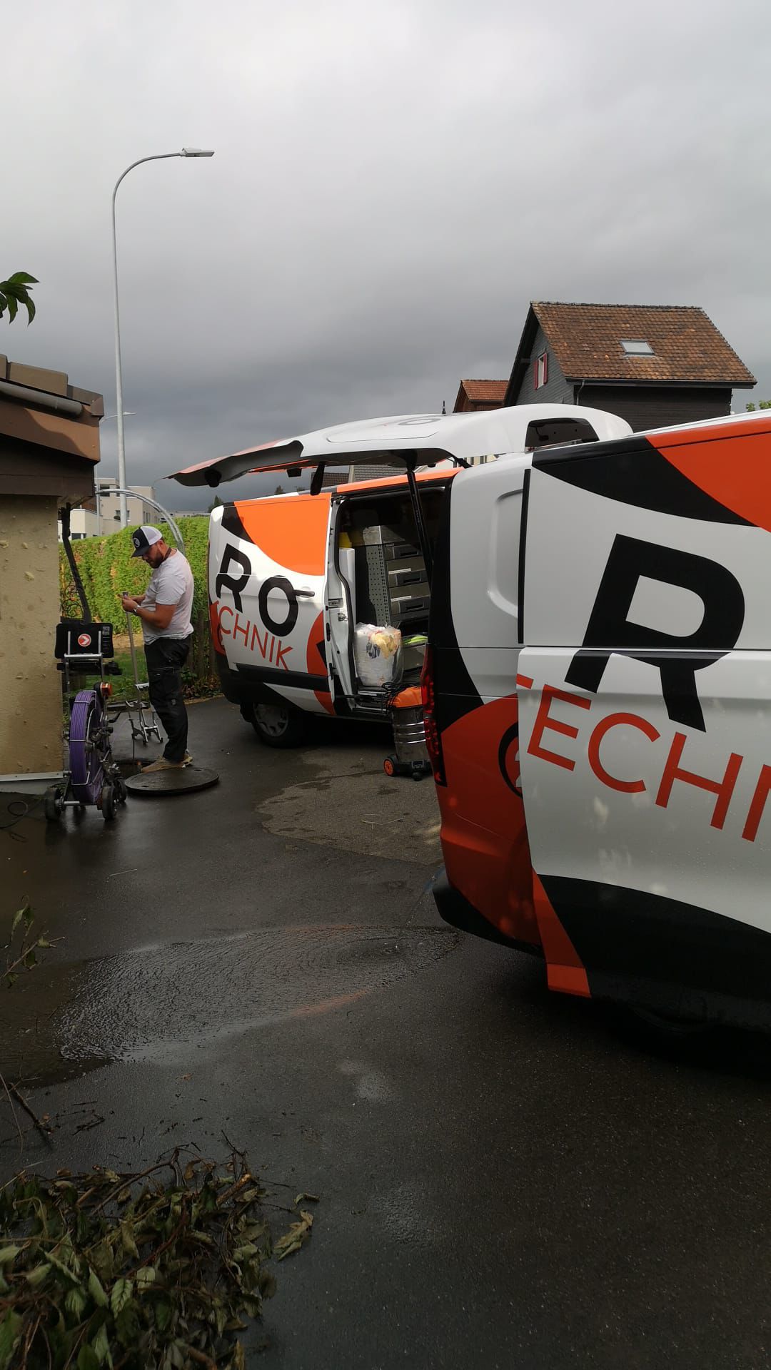Zwei Karo-Fahrzeuge bei einem Schachteinsatz an einer Liegenschaft bei Regen